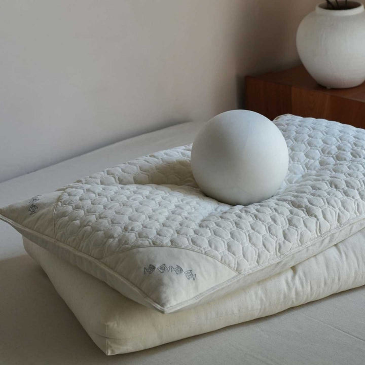 Ergonomic pillow with split filling of buckwheat shells and polyester fibers