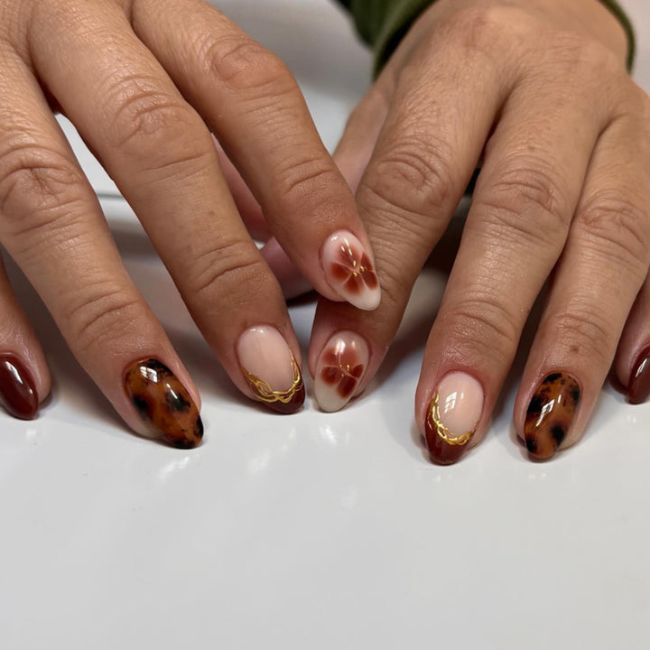 Artful acrylic nails with floral embellishments and glitter accents Kalsten