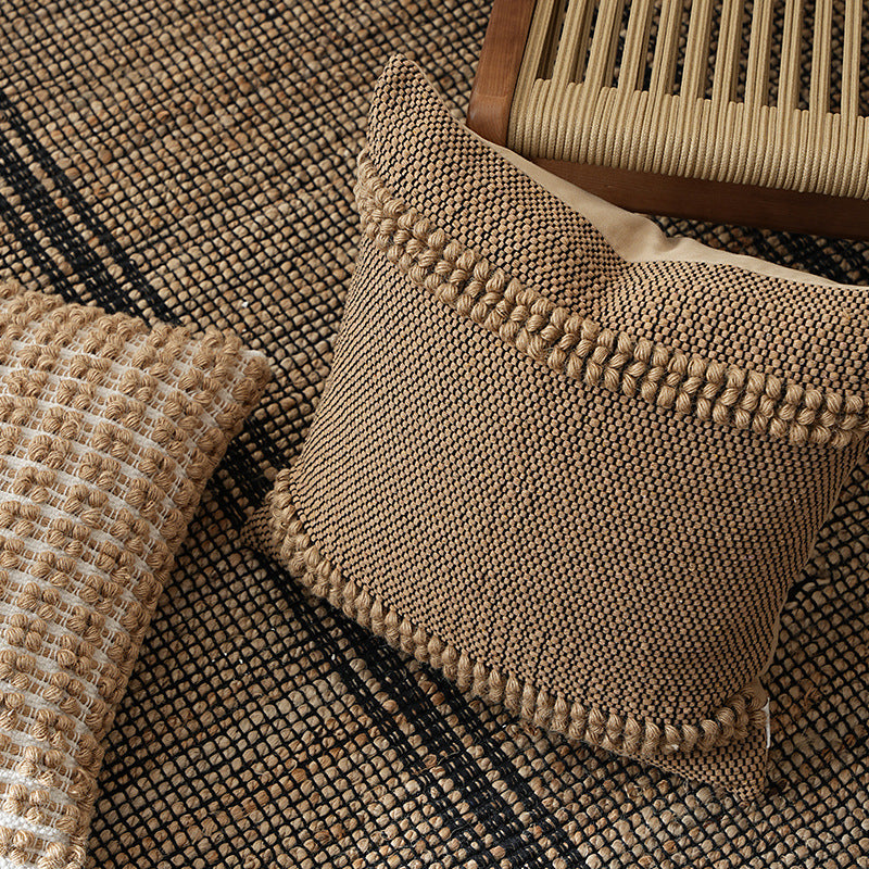 Square Boho decorative cushion made of coarsely woven cotton blend with decorative cord tufts