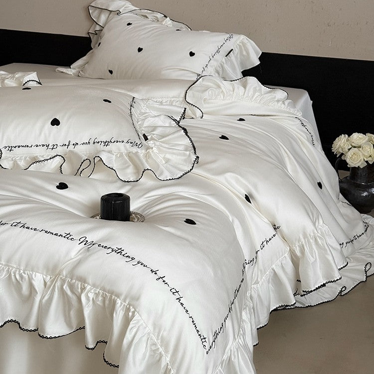 Luxurious cotton satin bedding set with ruffled trim, embroidered heart motifs, and calligraphic writing
