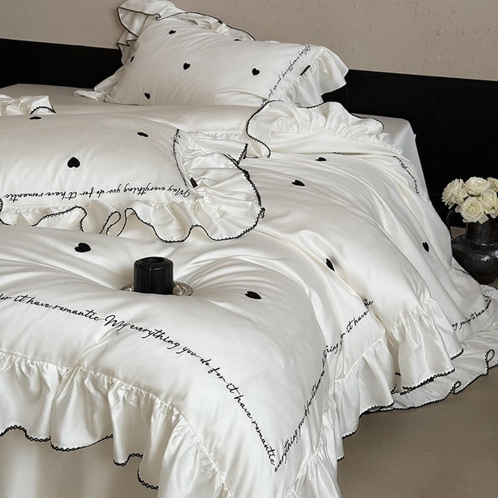 Luxurious cotton satin bedding set with ruffled trim, embroidered heart motifs, and calligraphic writing