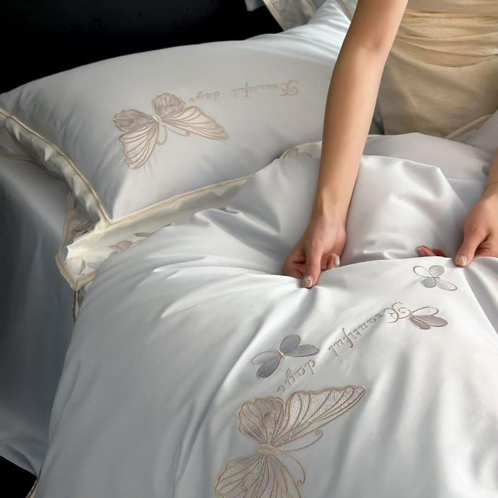 Satin bedding set with embroidered butterfly motif and silk-matte finish