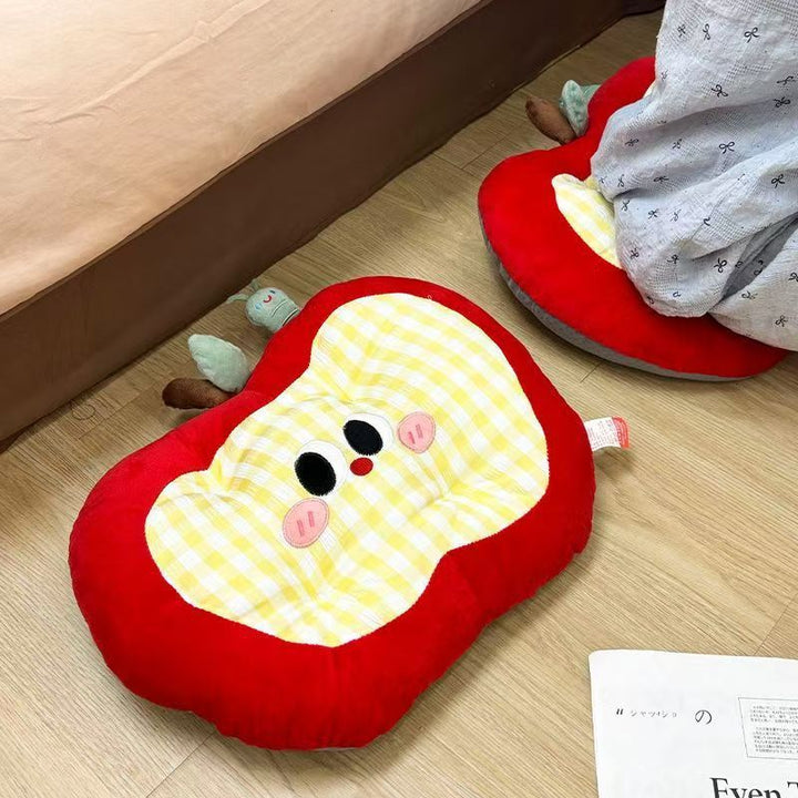 Padded children's seat cushion in apple shape with ergonomic seat recess and plush pendant