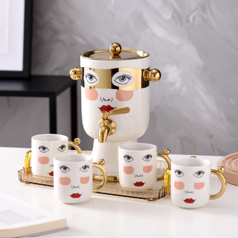 Decorative ceramic beverage dispenser with tap, hand-painted face and gold-finished lid