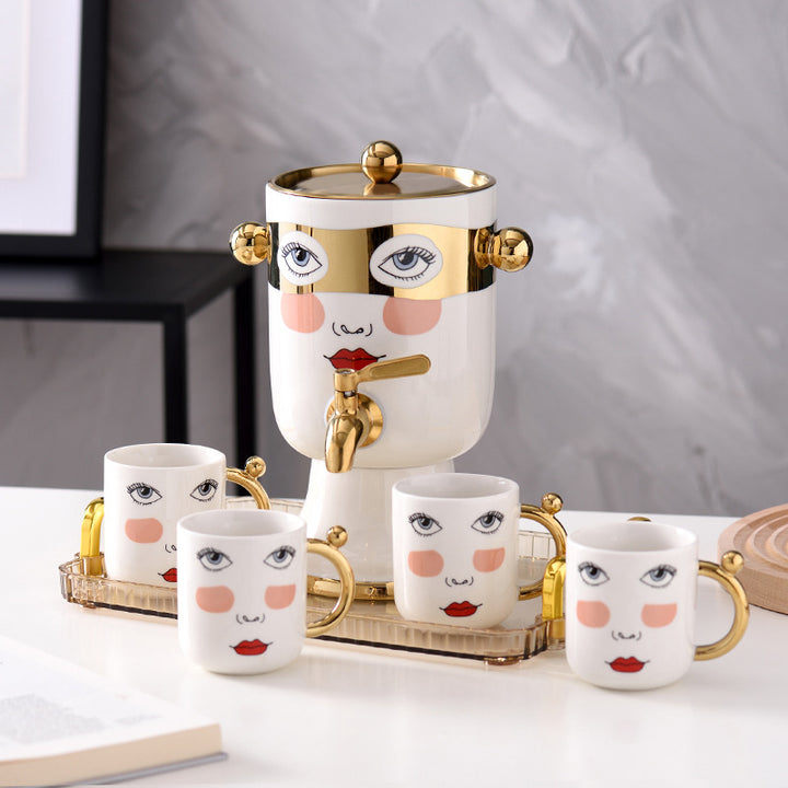 Decorative ceramic beverage dispenser with tap, hand-painted face and gold-finished lid