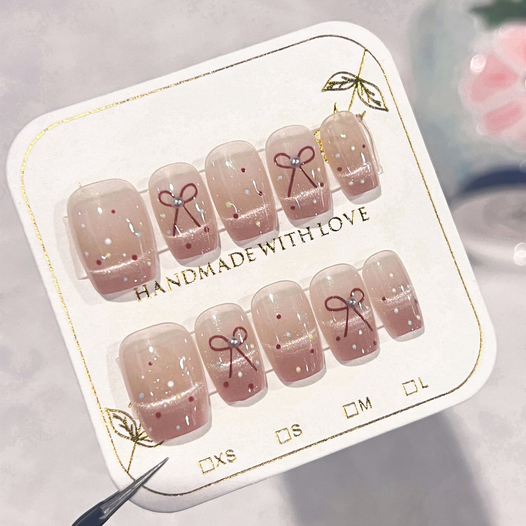 Artificial nail art with elegant bows and glitter accents Kalsten