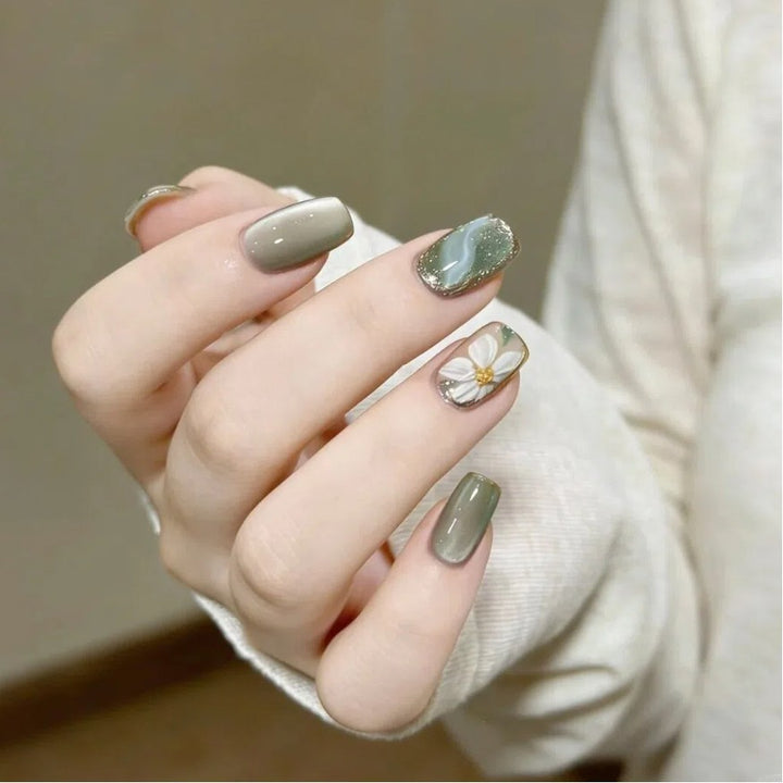 Artificial nails with floral accents and glamorous gold trim Kalsten