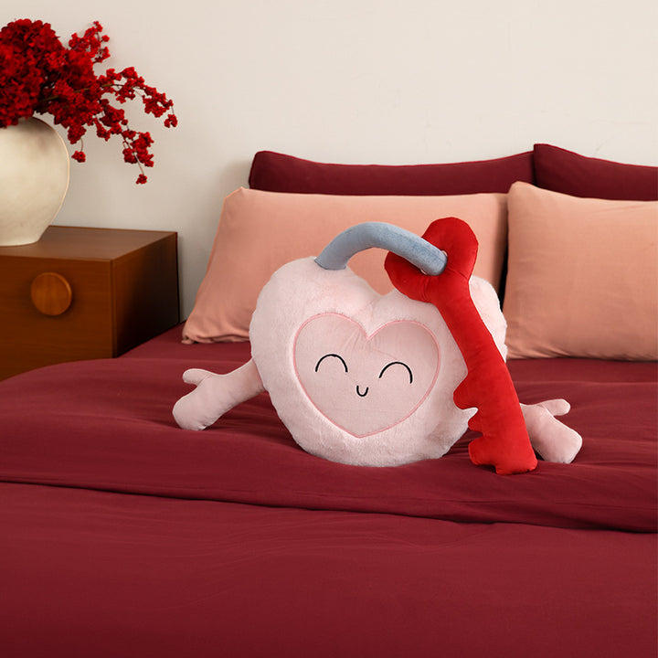 Heart-shaped cuddle castle cushion with attached key and friendly face