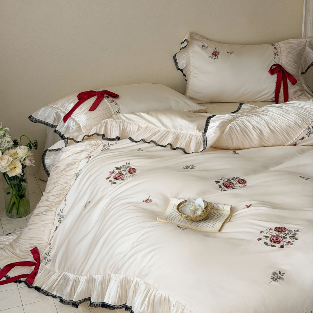 Elegant satin bedding set with pleated ruffle, rose embroidery, and bow appliqué