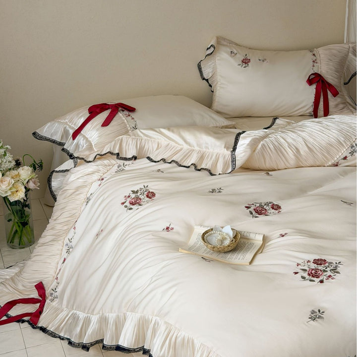 Elegant satin bedding set with pleated ruffle, rose embroidery, and bow appliqué