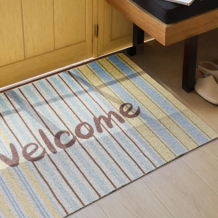 Woven door mat with welcome inscription, striped pattern and non-slip back