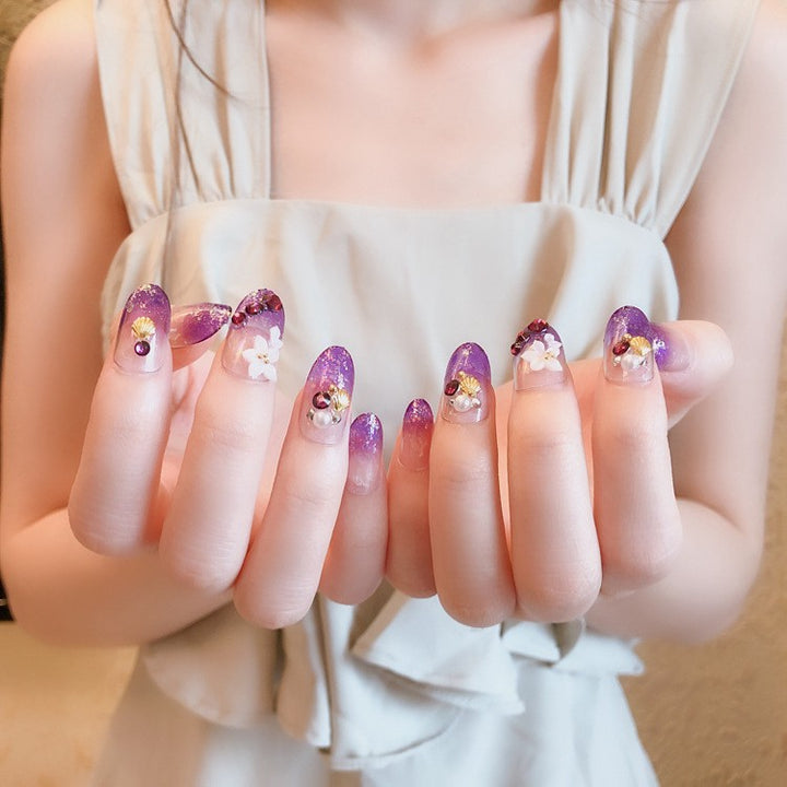 Artistic Press-On Nail Design with Glitter and Floral Accents