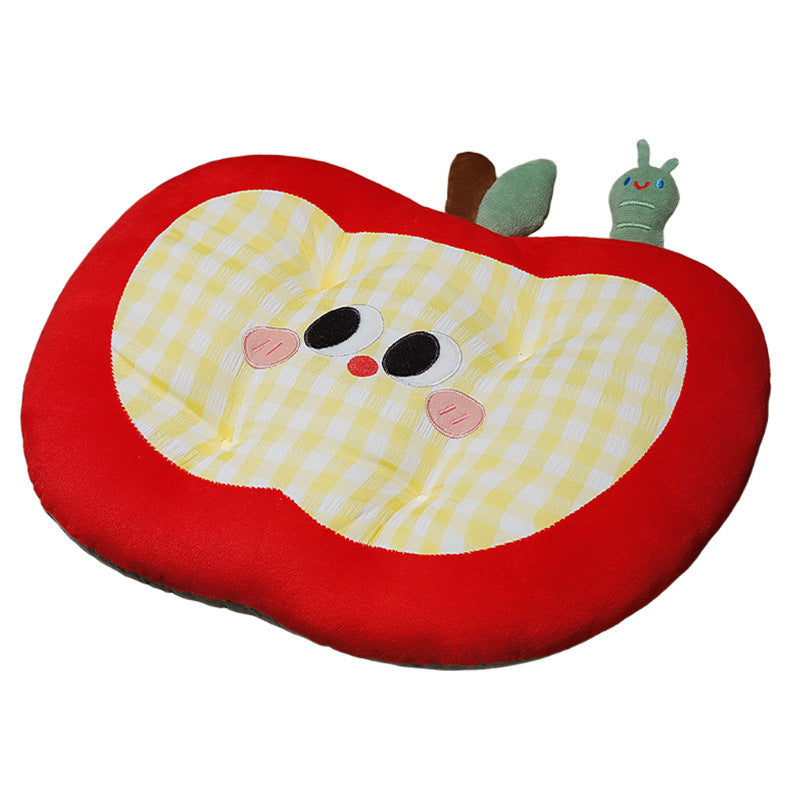 Padded children's seat cushion in apple shape with ergonomic seat recess and plush pendant