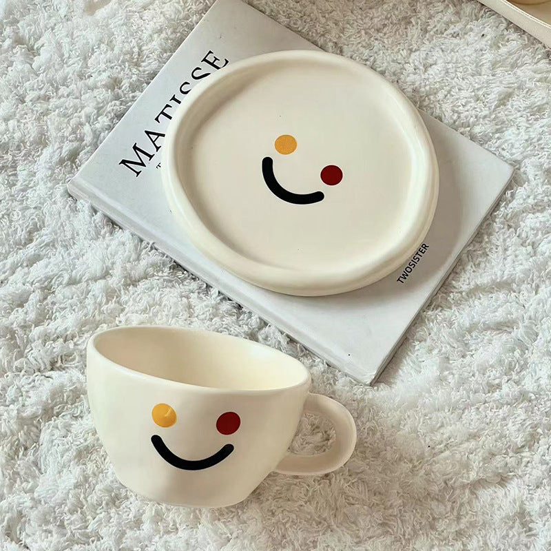 Handcrafted ceramic mug and plate set with cheerful smiley relief and organic shape