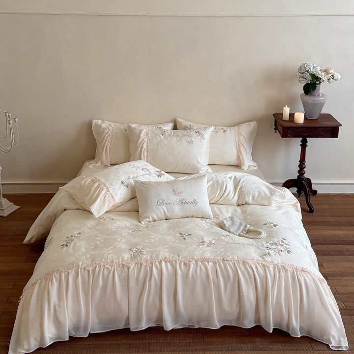Romantic satin bedding set with embroidered floral design, ruffle and pillowcases