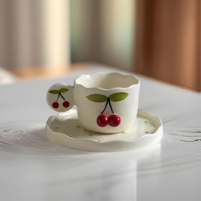 Hand-shaped espresso cup with wavy edge, round handle plate and applied cherry relief