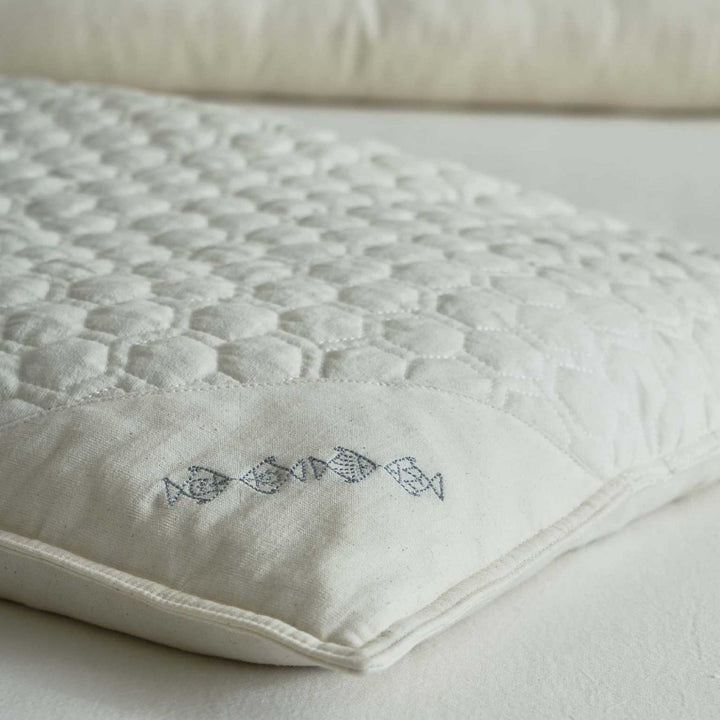 Ergonomic pillow with split filling of buckwheat shells and polyester fibers