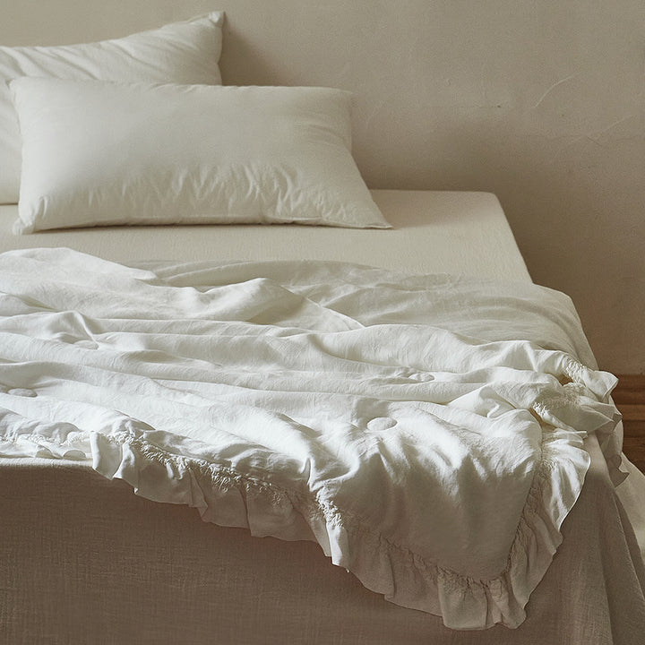 Light padded bedspread made of linen-cotton blend with gathered ruffle