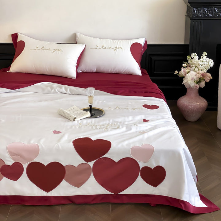 Bedding set with quilted heart appliqués and satin border