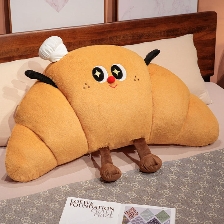 Large cuddly plush pillow in croissant shape with cute cartoon face