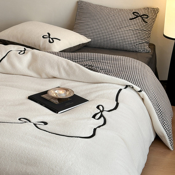 Reversible microfiber bedding set with plush surface, pom-pom corners, and paw embroidery