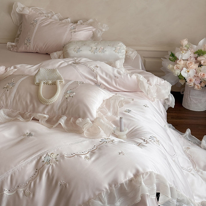 Satin bedding set with fine ruffle trim, delicate floral embroidery, and decorative pillowcases